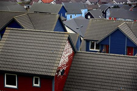 A woman leaves her Scandinavian style house in the town of Lerwick on the Shetland Islands April 3, 2014. REUTERS/Cathal McNaughton