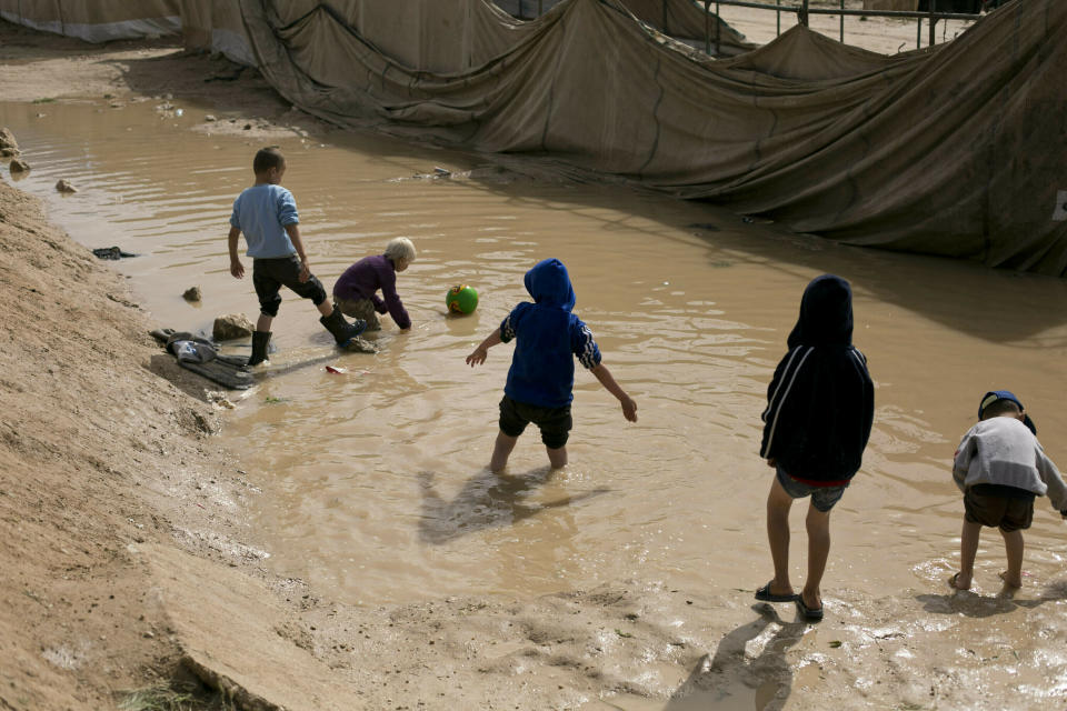 FILE - In this March 31, 2019 file photo, children play in a mud puddle in the section for foreign families at Al-Hol camp in Hasakeh province, Syria. The United Nations Children’s Fund on Monday, Dec. 7, 2020, launched a global appeal for a record $2.5 billion of emergency assistance for the Middle East and North Africa, saying the funds were necessary to respond to the needs of millions of children across a region hit hard by conflict, natural disaster and the coronavirus crisis. (AP Photo/Maya Alleruzzo, File)