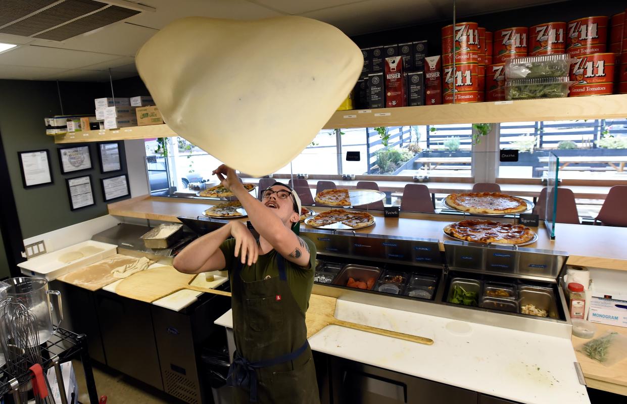 Sous-chef Tristan Gross tosses pizza dough as he spins it before making a pizza on Wednesday, Dec. 7, 2022, in Madison, Tenn. 