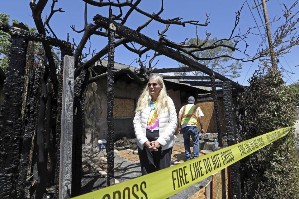 Gunilla Persson, star of the Swedish television reality show "Svenska Hollywoodfruar," or "Swedish Hollywood Wives" poses after a predawn fire severely damaged her home and a neighbor's in the Pacific Palisades area of Los Angeles Thursday, April 13, 2017. (AP Photo/Reed Saxon)