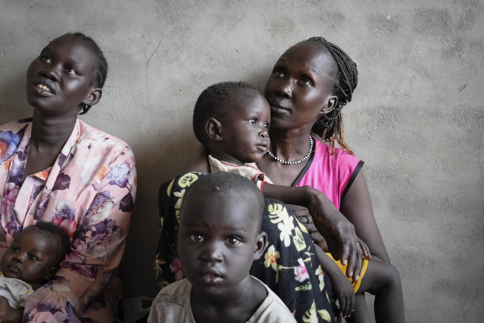 South Sudanese Alwel Ngok, 31, who fled from Sudan, sits holding her son next to others who also returned back, in a church in Renk, South Sudan Tuesday, May 16, 2023. Tens of thousands of South Sudanese are flocking home from neighboring Sudan, which erupted in violence last month. (AP Photo/Sam Mednick)