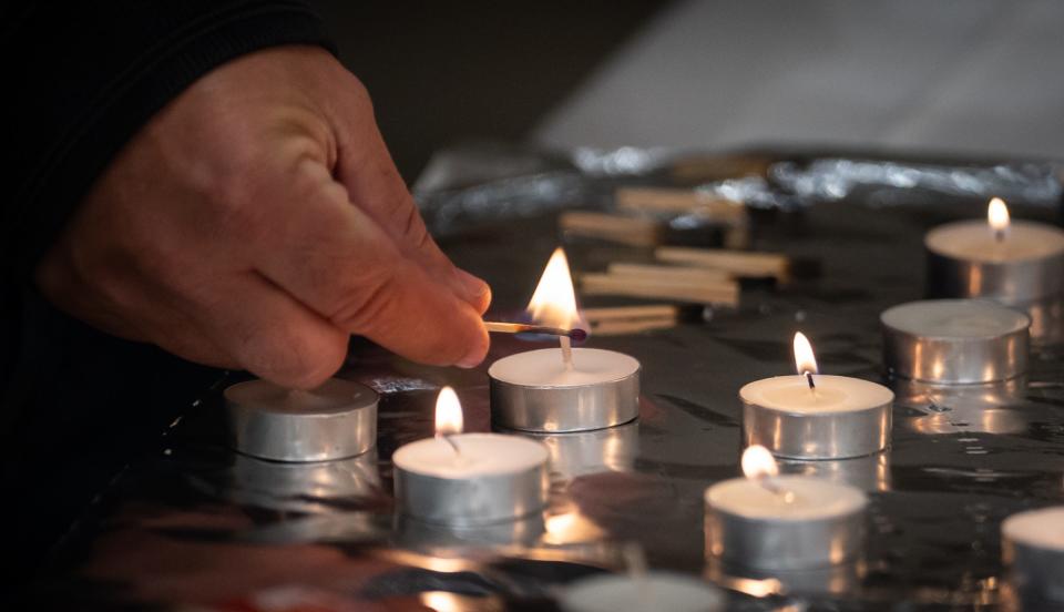 An audience member lights a candle for the Israeli hostages Nov. 16 before the Dell Jewish Community Center program, which included song and prayer for the hostages as well as a panel with their relatives.