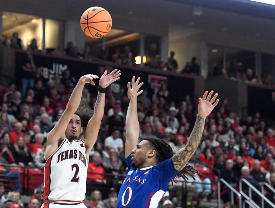 Texas Tech's guard Pop Isaacs (2), left, shoots the ball against Kansas during the Big 12 basketball game, Tuesday, Jan. 3, 2023, at United Supermarkets Arena. 