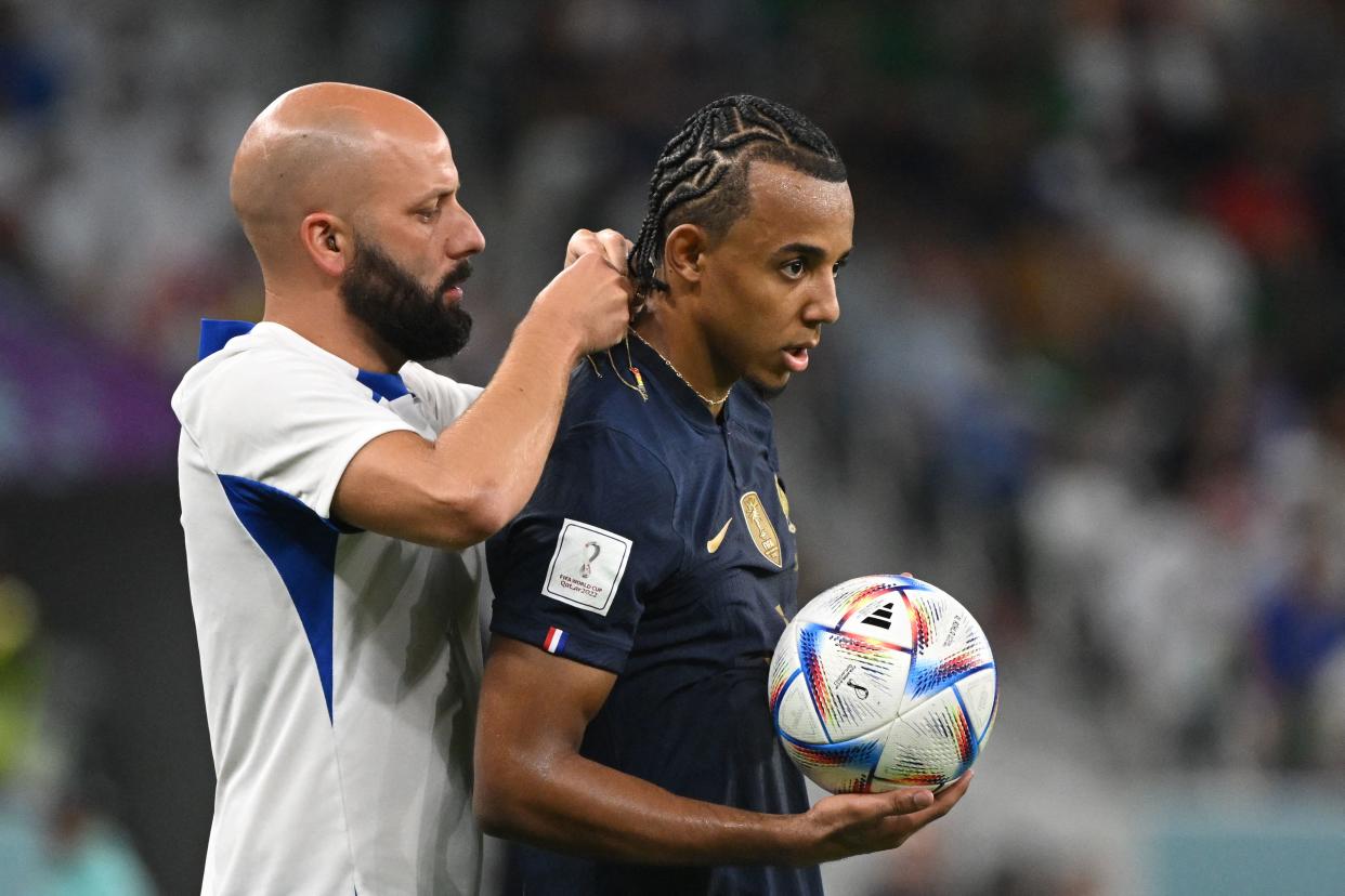 France's defender #05 Jules Kounde has his chain taken off during the Qatar 2022 World Cup round of 16 football match between France and Poland at the Al-Thumama Stadium in Doha on December 4, 2022. (Photo by ANDREJ ISAKOVIC / AFP) (Photo by ANDREJ ISAKOVIC/AFP via Getty Images)