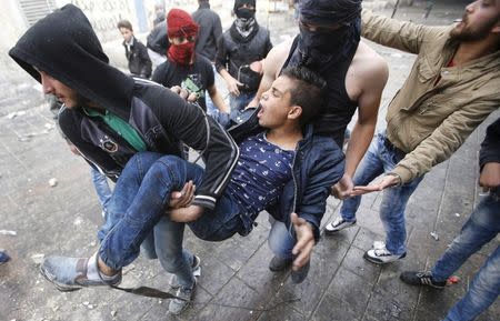 A Palestinian protester is carried by fellow protesters during clashes with Israeli troops in the West Bank city of Hebron November 5, 2015. REUTERS/Mussa Qawasma