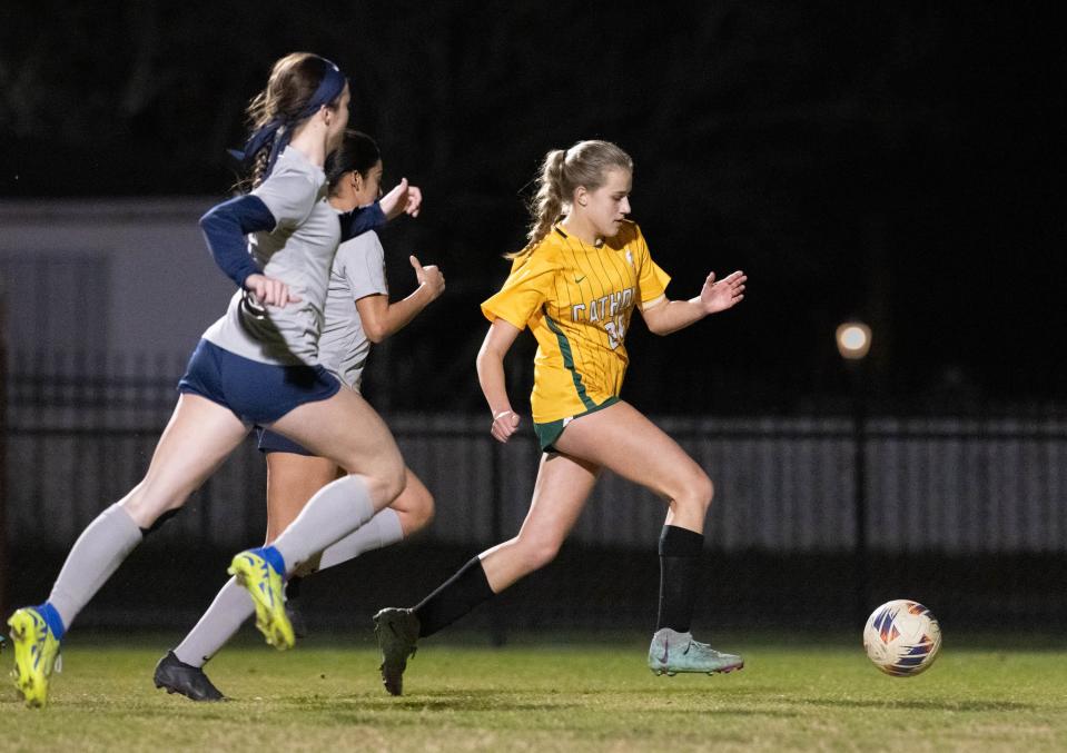 Cate Carlson (26) moves past the Braves defense to score a goal to give the Crusaders a 1-0 lead during the Walton vs Catholic girls playoff soccer game at Pensacola Catholic High School on Monday, Jan. 29, 2024.