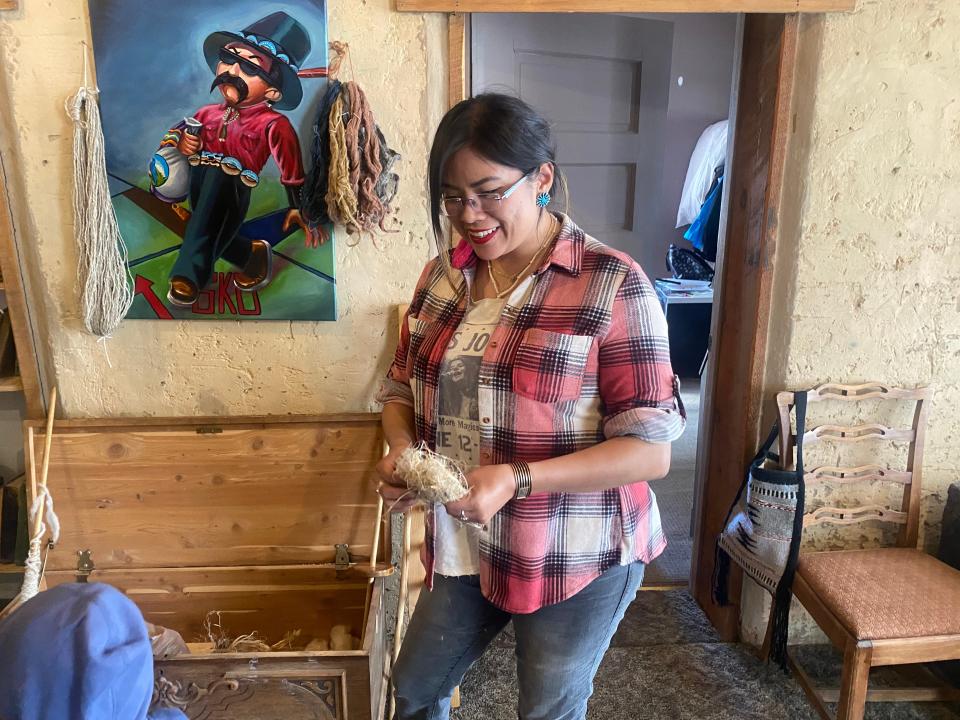 Shaylee Vandever, inside her brother Ira’s home, shows the hemp that will be processed and mixed with churro sheep wool to combine and used to weave Navajo rugs.