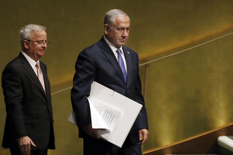 Israel's Prime Minister Benjamin Netanyahu, right, carries his speech and visual aids to address the 73rd session of the United Nations General Assembly, at U.N. headquarters, Thursday, Sept. 27, 2018. (AP Photo/Richard Drew)