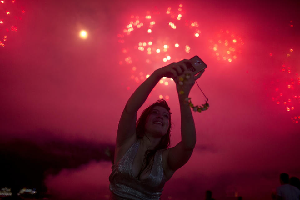 A woman takes a selfie during New Year's celebrations at Copacabana beach in Rio de Janeiro on January 1, 2018. (Photo: MAURO PIMENTEL via Getty Images)