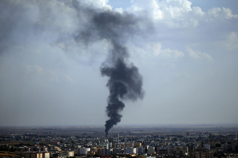 In this photo taken from the Turkish side of the border between Turkey and Syria, in Ceylanpinar, Sanliurfa province, southeastern Turkey, smoke billows from a fire in Ras al-Ayn, Syria, Friday, Oct. 18, 2019. Fighting broke out in the morning hours in the Syrian border town which has been a flashpoint in the fight between Turkey and Kurdish forces despite a U.S.-brokered cease-fire that went into effect overnight. The fighting died down in mid-morning. (AP Photo/Lefteris Pitarakis)