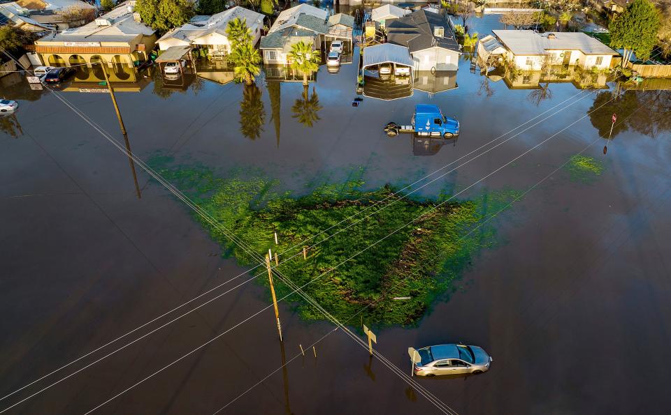 美國加州遭受風暴侵襲，各地下起暴雨，房屋、車輛皆遭洪水淹沒。（AFP）