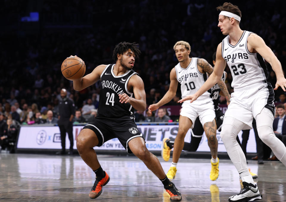 Brooklyn Nets guard Cam Thomas (24) drives to the against San Antonio Spurs forwards Zach Collins (23) and Jeremy Sochan (10) during the first half of an NBA basketball game, Saturday, Feb. 10, 2024, in New York. (AP Photo/Noah K. Murray)