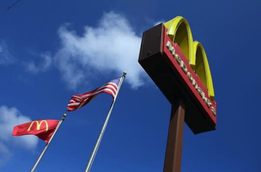 A sign for a McDonald's restaurant in front of an American flag on July 23, 2012 in Miami, Florida. Thousands of workers at McDonald's and other fast food outlets across the United States went on strike Thursday in a growing movement for higher wages in the industry