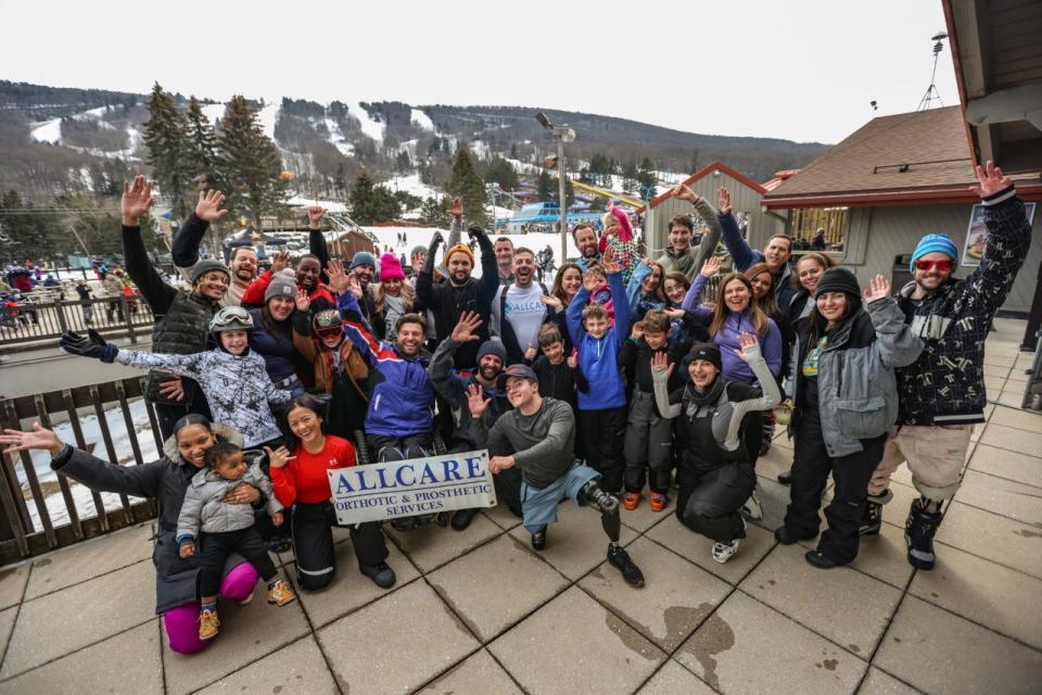 Eric Katz (seated behind the sign) at Camelback Ski Resort in Pennsylvania doesn't let disability get in the way of hitting the slopes.