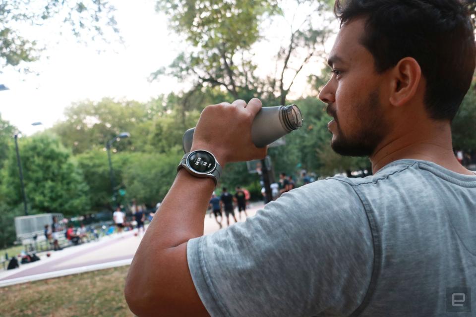 <p>The Samsung Galaxy Watch 5 Pro on the wrist of a person lifting up a water bottle to drink from it. A basketball game is taking place on the court in the background.</p>
