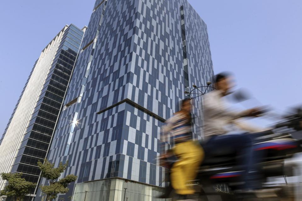 A motorcyclist travels past past GIFT Tower One, left, and GIFT Tower Two in Gujarat International Finance Tec-City (GIFT City), Gujarat, India, on Monday, Jan. 9, 2017. Photographer:  Dhiraj Singh/Bloomberg