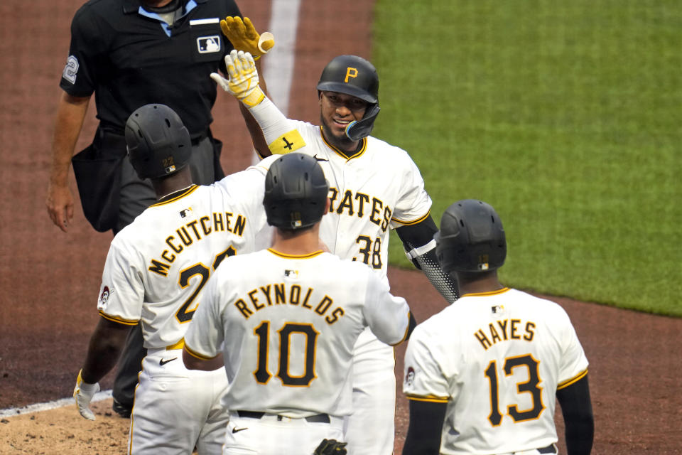 Pittsburgh Pirates' Edward Olivares (38) is greeted by Andrew McCutchen (22), Bryan Reynolds (10) and Ke'Bryan Hayes (13) after hitting a grand slam off Los Angeles Angels starting pitcher Tyler Anderson during the third inning of a baseball game in Pittsburgh, Monday, May 6, 2024. (AP Photo/Gene J. Puskar)