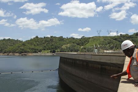 An official of the Zimbabwe Electricity Supply Authourity (ZESA) inspects water levels on the Kariba dam in Kariba, Zimbabwe, February 19, 2016. REUTERS/Philimon Bulawayo