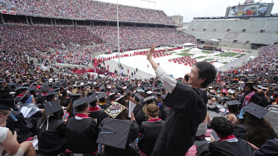 Boyu Zhin tries to make contact with a friend during the Ohio State Spring 2024 Commencement held Sunday, May 5, 2024 in Ohio Stadium. He earned a bachelor's degree from the College of Education and Human Ecology.