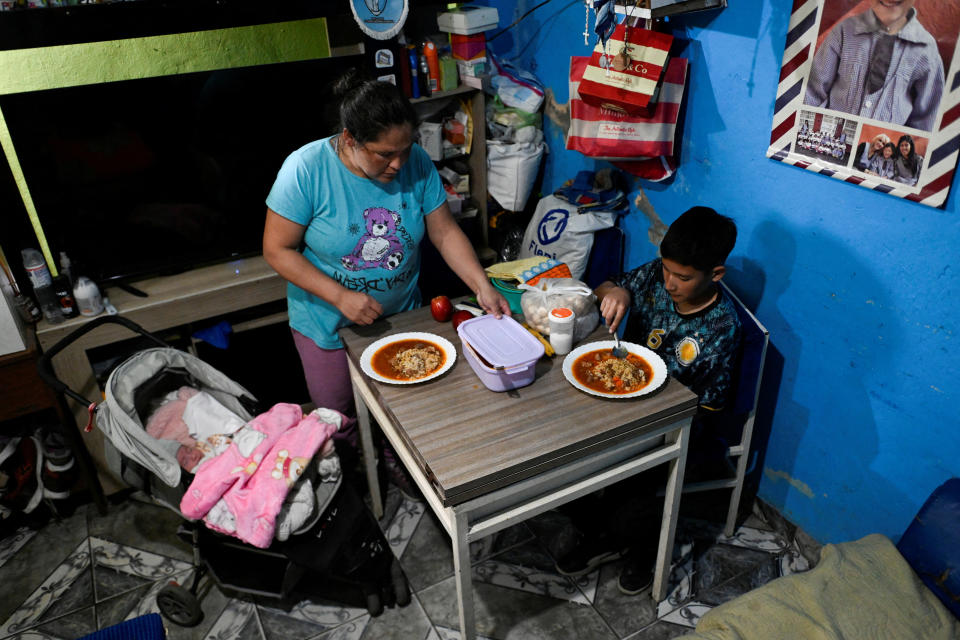 Lilian González, de 36 años, prepara una comida con los alimentos que recibió de un comedor social, junto a su hijo, Joaquín Mendieta, de 11 años, y su hija, Dana Mendieta, en Villa Soldati, en las afueras de Buenos Aires, Argentina, el 16 de septiembre de 2024. REUTERS/Mariana Nedelcu/Foto de archivo