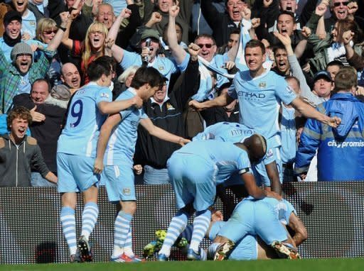 Manchester City's Sergio Aguero celebrates his late winning goal with team-mates during the Premier League match against Queens Park Rangers at The Etihad Stadium in Manchester. Manchester City won the game 3-2 to secure their first title since 1968