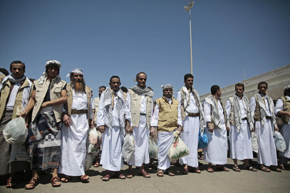 Yemeni prisoners gather during their arrival after being released by the Saudi-led coalition at the airport in Sanaa, Yemen, Friday, Oct. 16, 2020. Yemen's warring sides completed a major, U.N.-brokered prisoner swap on Friday, officials said, a development that could revive the country's stalled peace process after more than five years of grinding conflict. (AP Photo/Hani Mohammed)