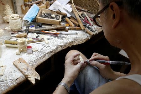 A worker crafts an ivory product from government registered ivory tusk inside a factory in Hong Kong, China June 27, 2016. REUTERS/Bobby Yip