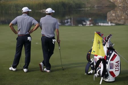 U.S. team member Jordan Spieth (R) and Dustin Johnson stand on the green of fifth hole during the practice round for the 2015 Presidents Cup golf tournament at the Jack Nicklaus Golf Club in Incheon, South Korea, October 7, 2015. REUTERS/Kim Hong-Ji