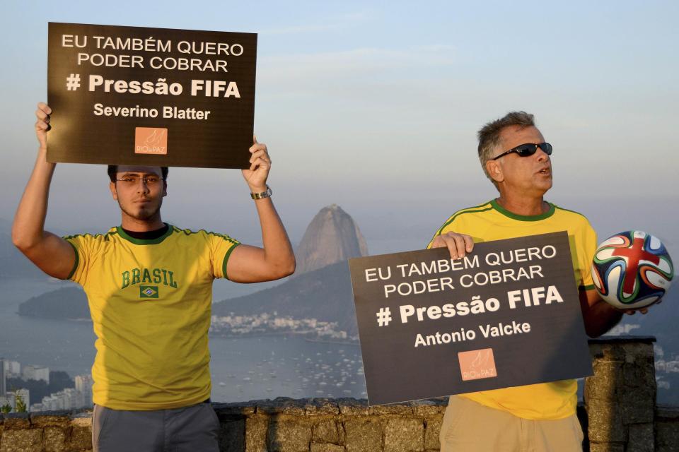 Members of NGO Rio de Paz hold signs during a protest against the 2014 World Cup in Rio de Janeiro