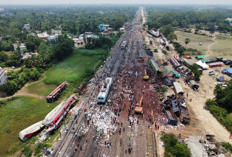 A drone view shows diggers remove damaged coaches following trains collision in Balasore