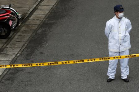 A police officer stands guard at a location where the suspected arsonist was detained, near the Kyoto Animation building which was torched by arson attack, in Kyoto