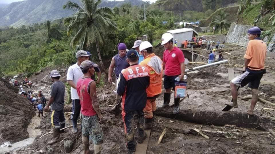 In this image provided by the Department of Public Works and Highways, Mountain Province District Engineering Office, rescuers dig through the earth to search for survivors after a massive landslide in Natonin township, Mountain Province in northern Philippines Wednesday, Oct. 31, 2018. A massive landslide set off by a typhoon crashed down on two government buildings in a northern Philippine mountain province, officials said Wednesday. (DPWH MPDSEO via AP)