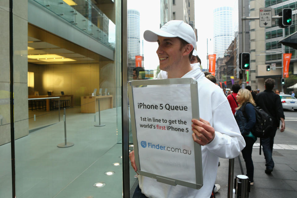 SYDNEY, AUSTRALIA - SEPTEMBER 21: A marketer promotes a brand in the queue the iPhone 5 at the Apple flagship store on George street on September 21, 2012 in Sydney, Australia. Australian Apple stores are the first in the world to receive and sell the new iPhone 5 handsets. (Photo by Cameron Spencer/Getty Images)