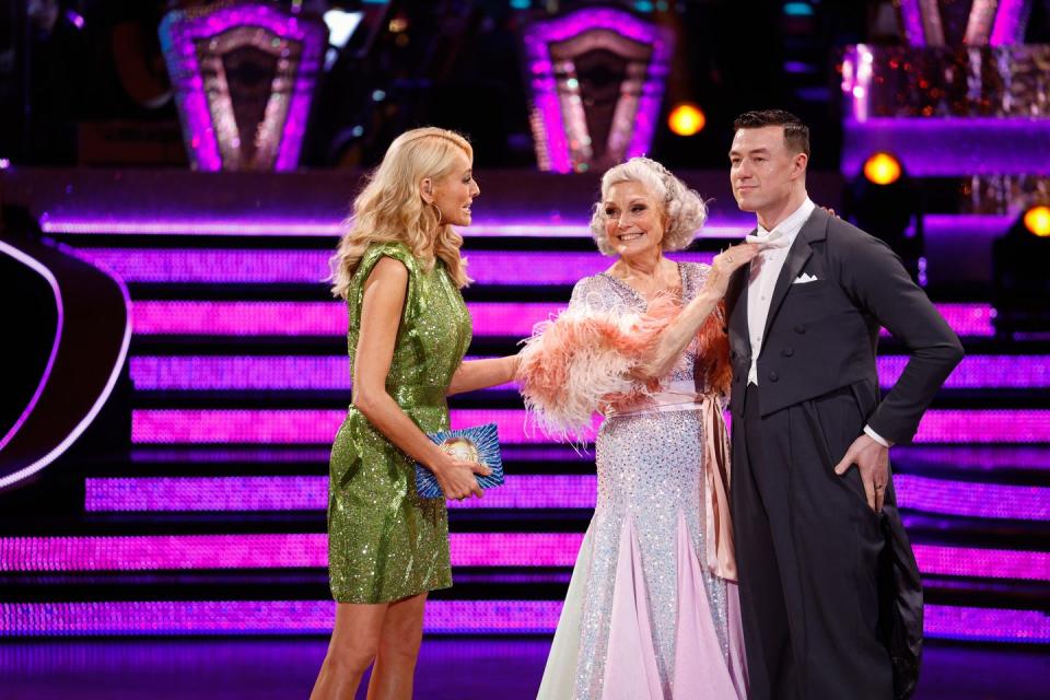 tess talks to angela and kai on the ballroom floor after their elimination from strictly