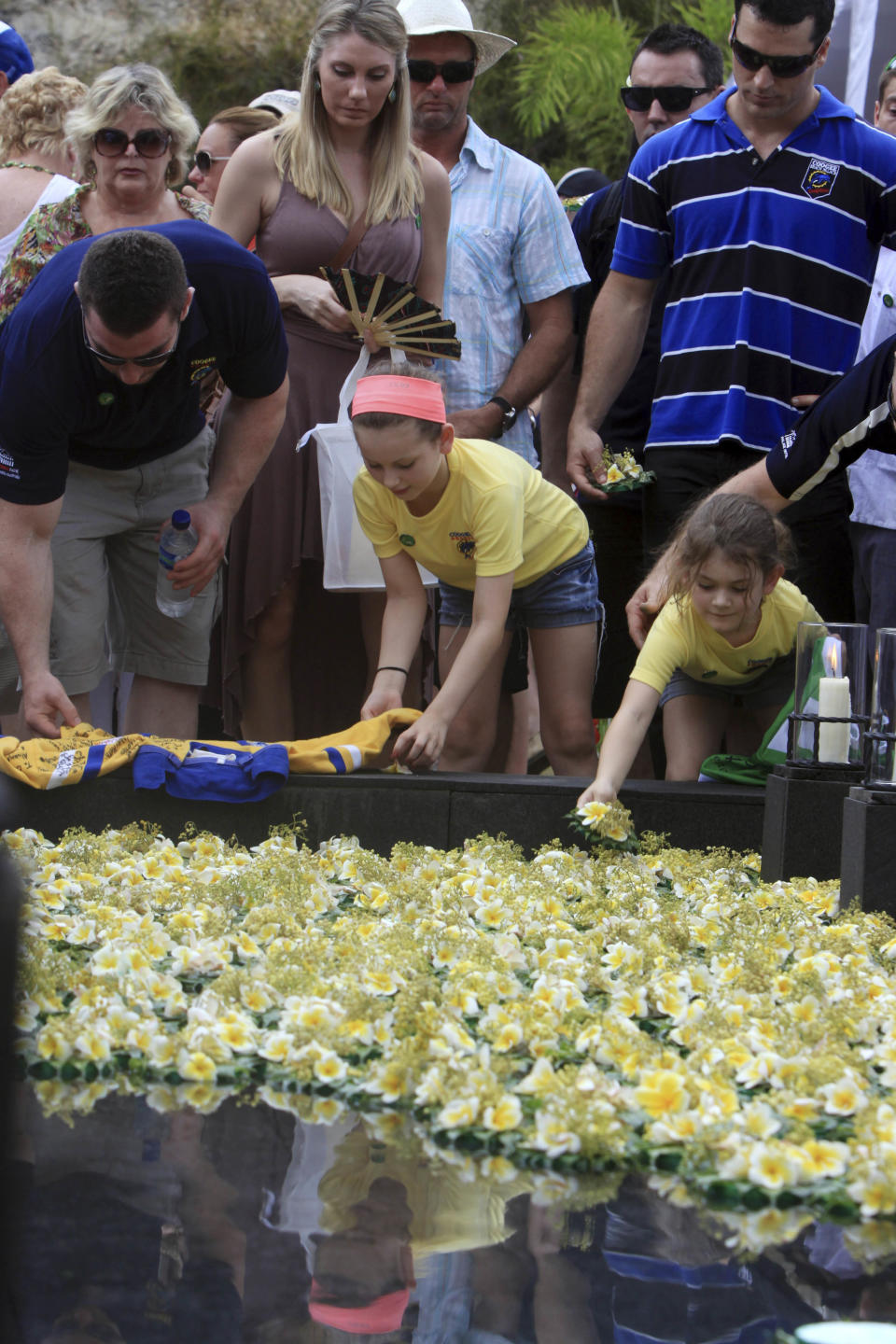 Relatives and survivors of the 2002 Bali bombings offer flowers during a memorial service to mark the 10th anniversary of the terrorists attacks in Kuta, in Jimbaran, Bali, Indonesia, Friday, Oct. 12, 2012. A decade after twin bombs killed scores of tourists partying at two beachfront nightclubs on Indonesia's resort island of Bali, survivors and victims' families on Friday braved a fresh terrorism threat to remember those lost to the tragedy. (AP Photo/Firdia Lisnawati)