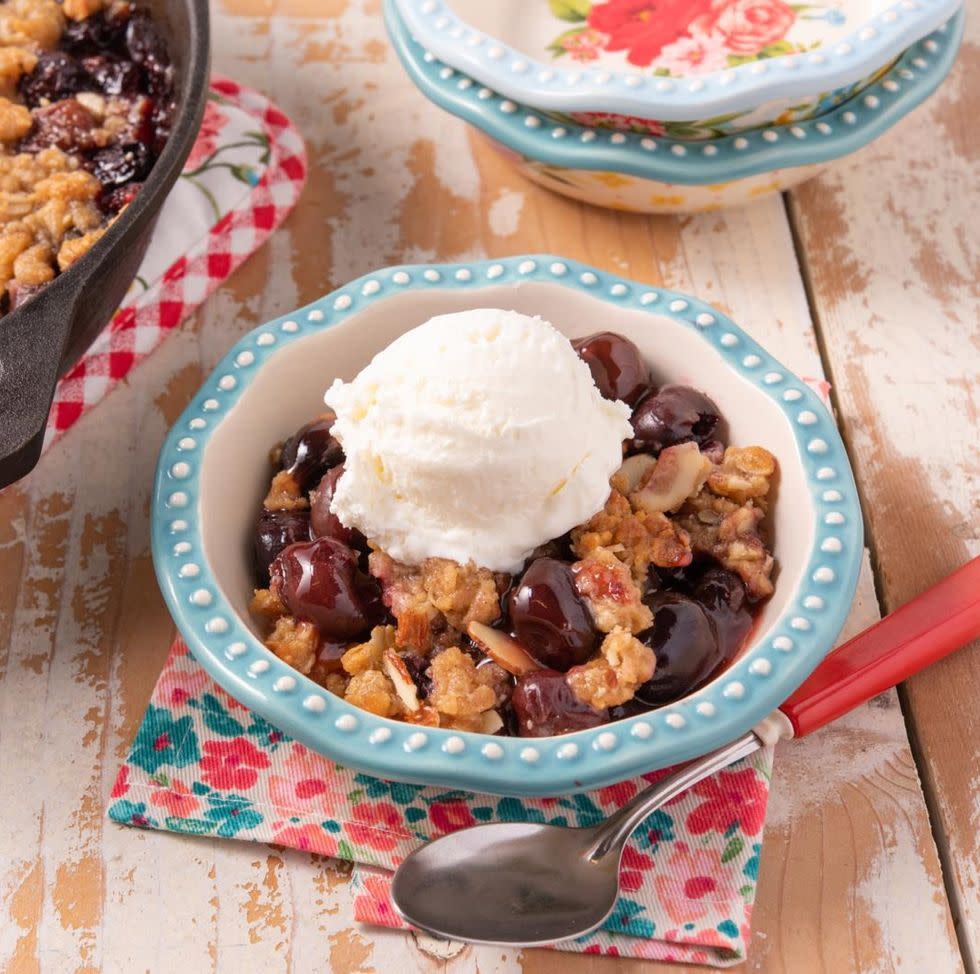 cherry crisp in bowl with vanilla ice cream on top