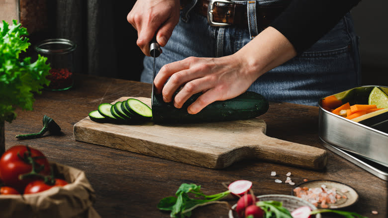 Person cutting cucumbers