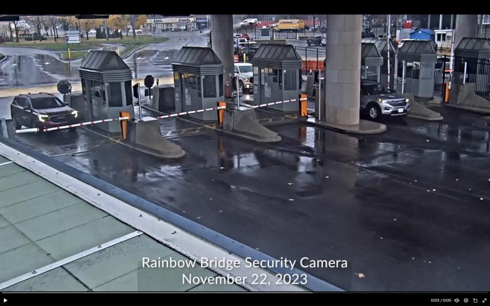 This screengrab from the security camera footage provided by CBP (US Customs and Border Protection) shows a car flying in the background of the US-Canada checkpoint of the Rainbow Bridge border crossing in Niagara Falls (US Customs and Border Protection)