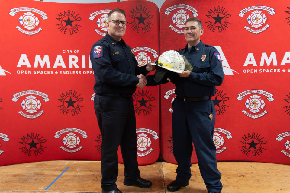 Amarillo Fire Chief Jason Mays presents retiring Deputy Fire Chief Sam Baucom a signed helmet Friday at his retirement ceremony in downtown Amarillo.