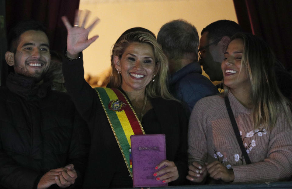 Bolivia's second Senate Vice President and opposition politician Jeanine Anez, center, wearing the Presidential sash, addresses the crowd from the balcony of the Quemado palace after she declared herself interim president of the country, in La Paz, Bolivia, Tuesday, Nov. 12, 2019. (AP Photo/Juan Karita)