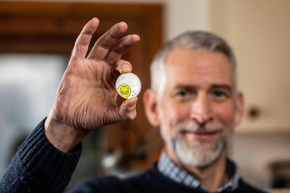 Adam Hargreaves, son of Mr Men and Little Miss creator Roger Hargreaves, holds The Royal Mint's new £5 Mr Happy coin, which launches today to celebrate 50 years of the characters. Photo: PA Media