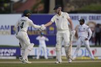 Australia's Cameron Green is congratulated by Alex Carey for scoring a half century during the day two of the first test cricket match between Australia and Sri Lanka in Galle, Sri Lanka, Thursday, June 30, 2022. (AP Photo/Eranga Jayawardena)