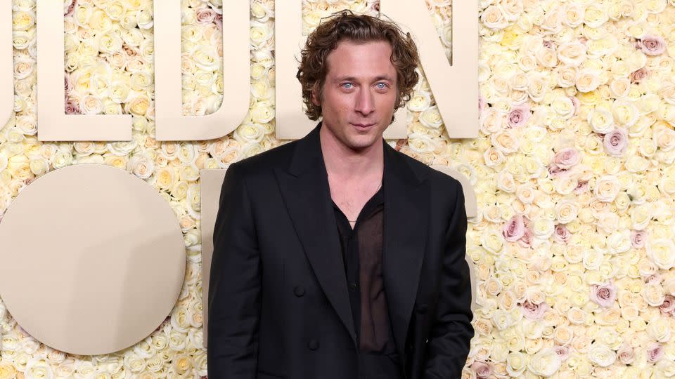 “The Bear” actor Jeremy Allen White wore a custom black Calvin Klein tuxedo consisting of a double-breasted wool jacket with satin grosgrain lapels, high-waisted trousers and a sheer silk voile shirt. - Kevin Mazur/Getty Images