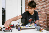 Danylo Boichuk, 12, shows his one of his LEGO constructions during an interview at his home in the village of Gorenichi outside Kyiv, Ukraine, on Tuesday, May 5, 2020. Ever since Ukraine imposed a lockdown to curb the spread of the coronavirus, and schools brought all their classes online, Danylo has been missing his friends _ especially a girl named Karina. (AP Photo/Efrem Lukatsky)
