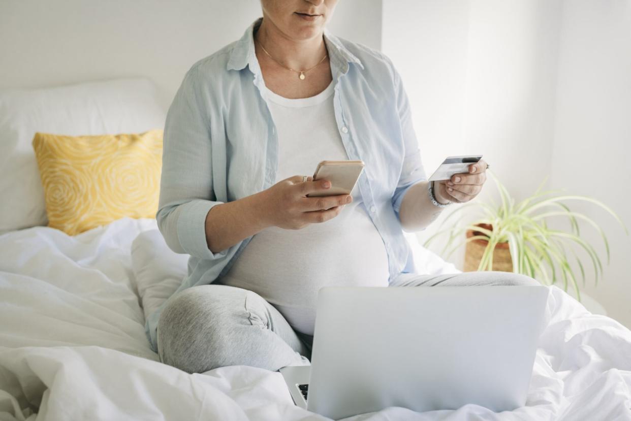 Young woman sitting on the bed and working on laptop