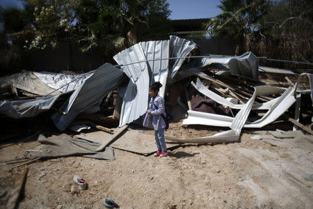 A Palestinian girl stands outside her family structure after it was demolished by Israeli forces near the West Bank city of Jericho April 7, 2016. REUTERS/Mohamad Torokman