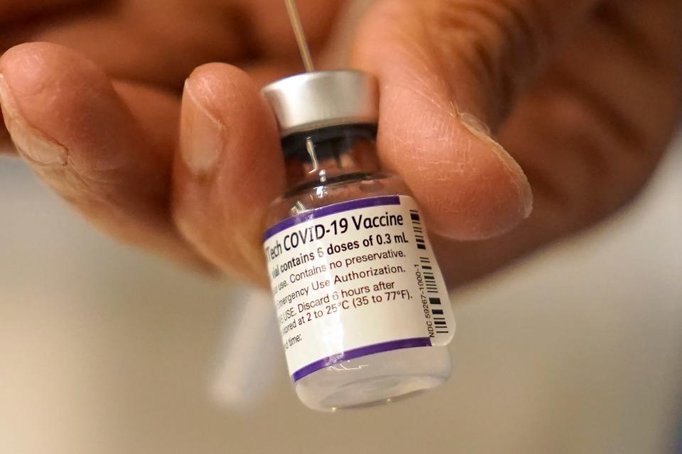 Dr. Manjul Shukla transfers Pfizer COVID-19 vaccine into a syringe on Dec. 2 at a mobile vaccination clinic in Worcester, Mass.