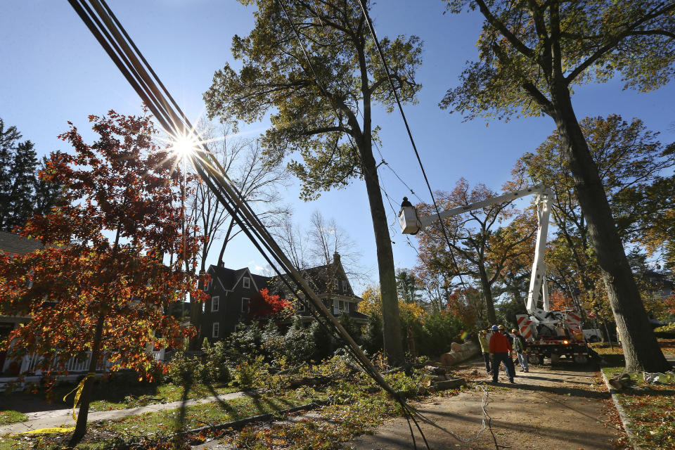 Crews from Madison Electric and Butler Municipal Power and Light work on downed power lines on Green Hill Road Friday, Nov. 1, 2019, in Madison, N.J. The borough was hit by high winds on heavy rain late the night before. (AP Photo/Rich Schultz)