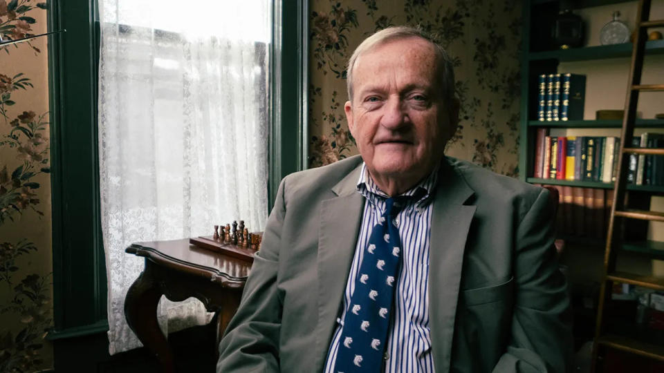 John Allen wearing a gray blazer and a blue shirt