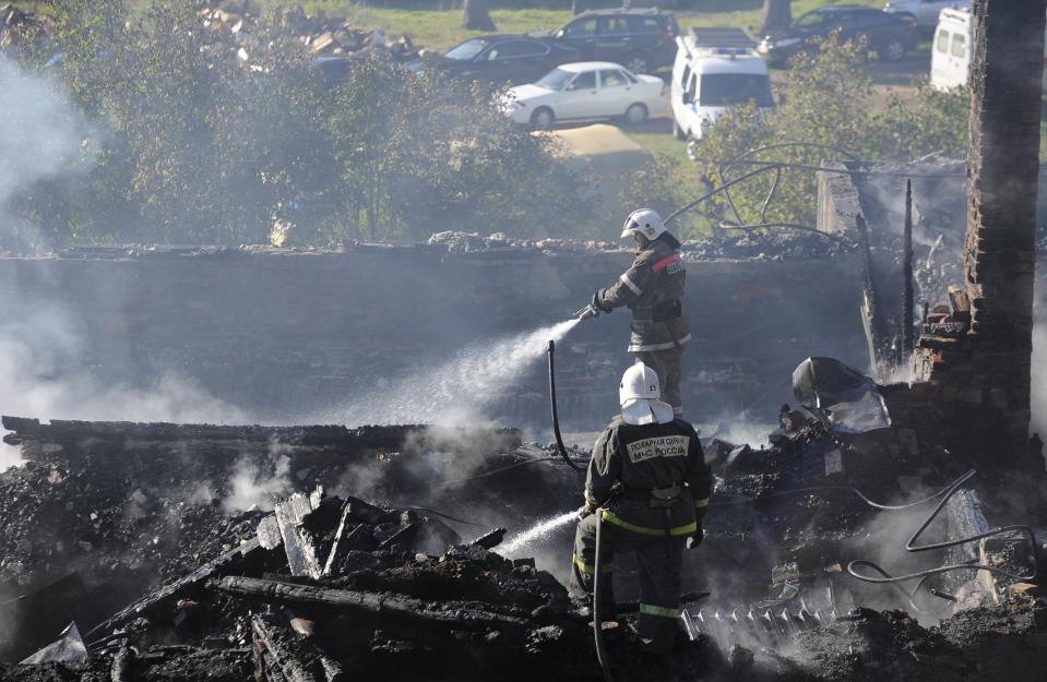 Firefighters work amidst the debris of a psychiatric hospital destroyed by fire in the Novgorod region town of Luka September 13, 2013. The fire raged through the Russian psychiatric hospital on Friday, killing at least one person and leaving dozens missing as police searched the surrounding area for survivors, emergency and law enforcement officials said. (REUTERS/Lyudmila Popova)